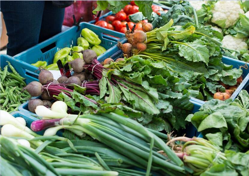 Verschillende soorten groenten liggen uitgestald in een marktkraam