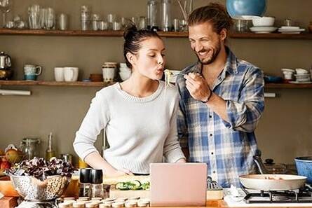 a couple in the kitchen preapering a meal