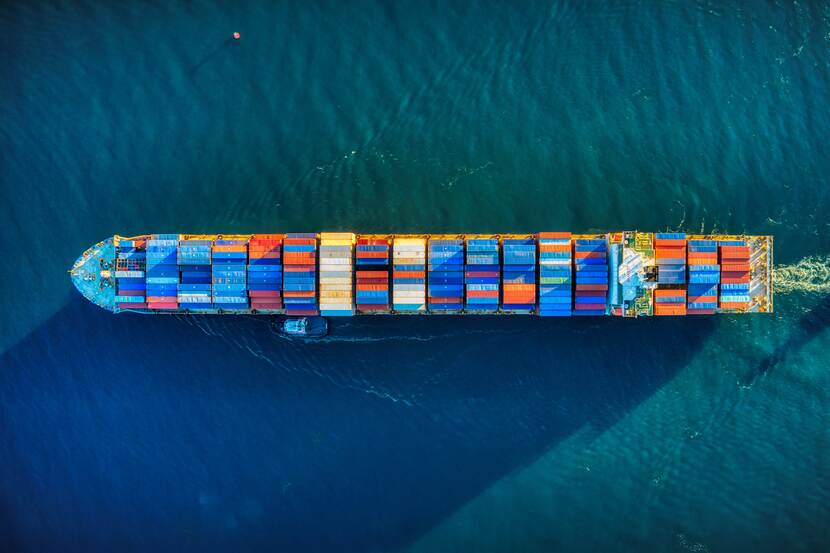 Aerial view of a cargo ship traveling through the sea