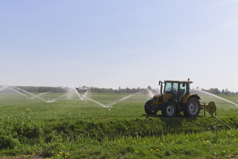 tractor and water spraying on crops